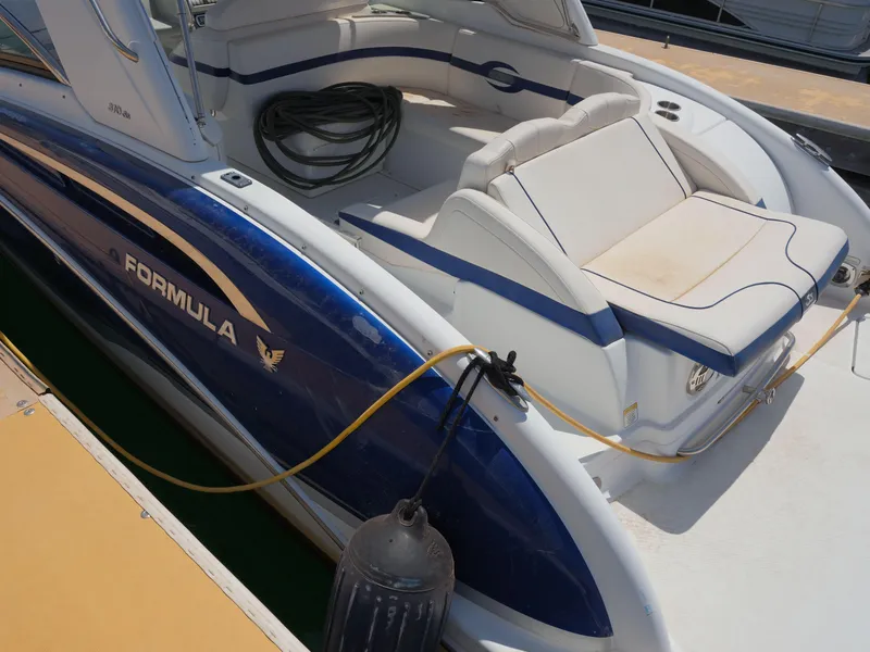 Slide: The Image of 2012 Formula 310 Sun Sport boat docked, featuring blue and white exterior. - 15