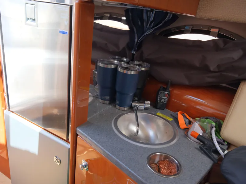 Slide: The Image of 2012 Formula 310 Sun Sport boat interior with kitchenette, sink, and stainless steel refrigerator. - 24