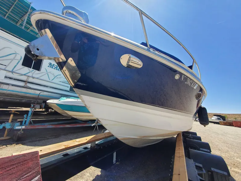 Slide: The Image of 2012 Formula 310 Sun Sport boat on trailer, blue and white hull, docked outdoors. - 31