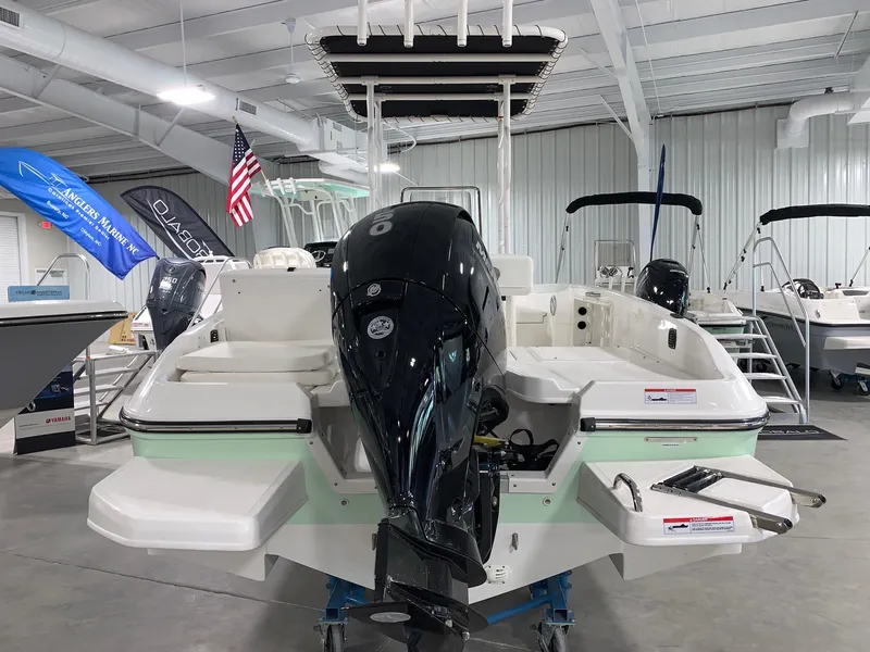 Slide: The Image of 2024 Bayliner T21 Bay boat in showroom, rear view with outboard motor. - 2