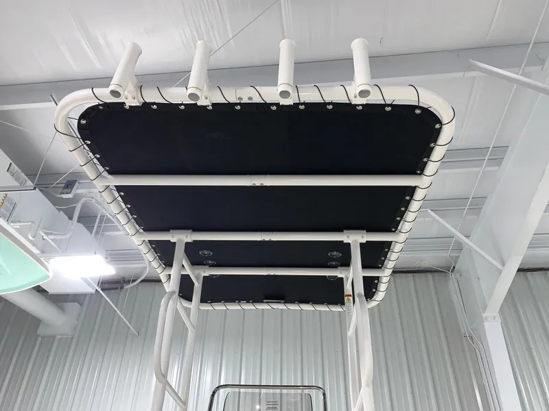 Slide: The Image of 2024 Bayliner T21 Bay boat T-top with rod holders in a showroom. - 4