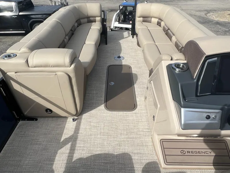 Slide: The Image of 2022 Regency 250 LE3 pontoon boat with beige seating and spacious deck. - 3
