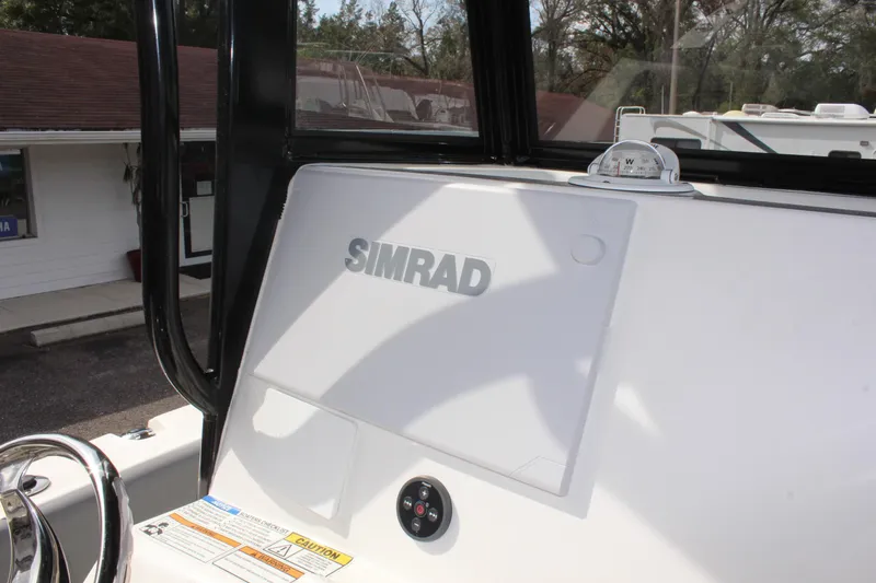 Slide: The Image of 2023 NauticStar 251 Hybrid boat dashboard with Simrad navigation system. - 12