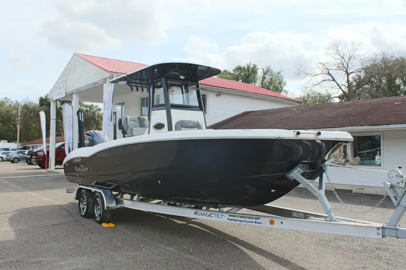 Slide: The Image of 2023 NauticStar 251 Hybrid boat on trailer, parked outdoors. - 2
