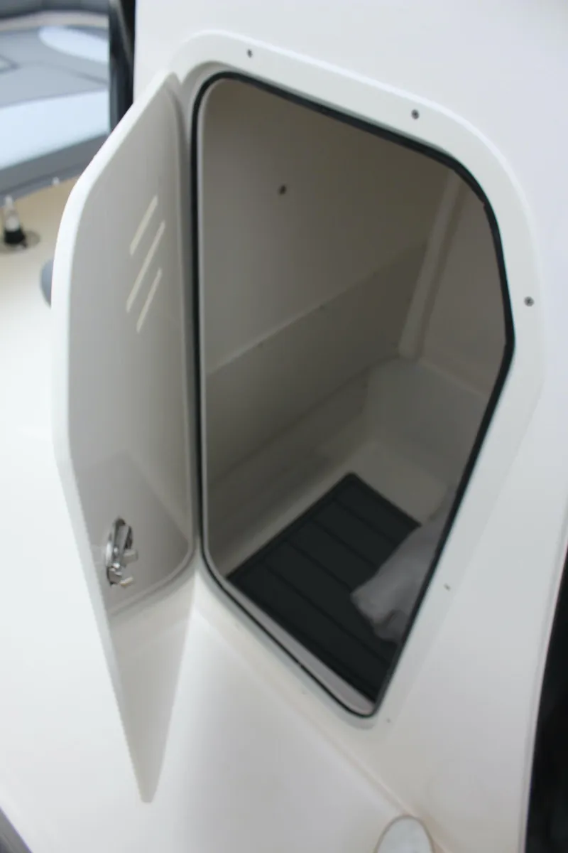 Slide: The Image of 2023 NauticStar 251 Hybrid storage compartment with open door. - 22