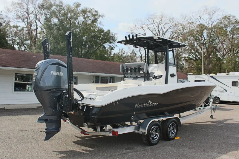 Slide: The Image of 2023 NauticStar 251 Hybrid boat on trailer with Yamaha engine, parked outdoors. - 4