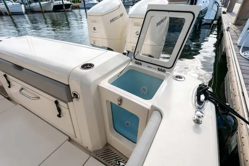 Slide: The Image of 2026 Scout 377 LXF boat with open storage compartment at dock. - 14