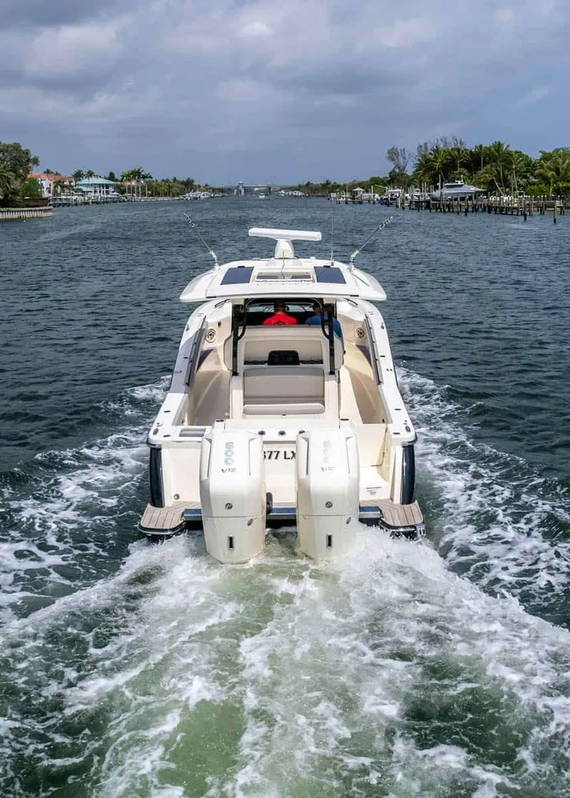 Slide: The Image of 2026 Scout 377 LXF boat on water, rear view. - 20