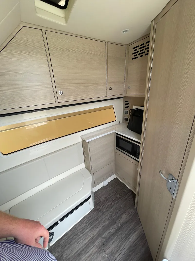 Slide: The Image of Interior of 2025 Scout 377 LXF boat with modern cabinetry and seating. - 4