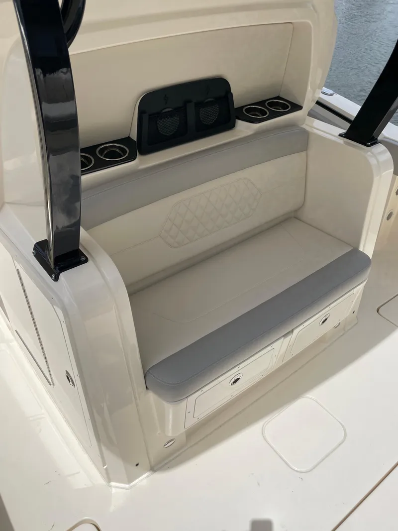 Slide: The Image of 2025 Scout 377 LXF boat seating area with storage compartments and cup holders. - 7