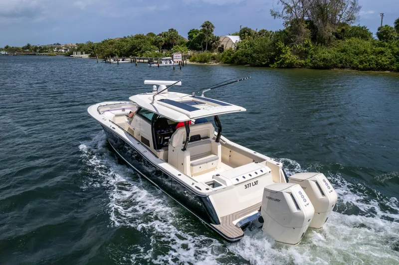 Slide: The Image of 2025 Scout 377 LXF boat cruising on a scenic waterway. - 9