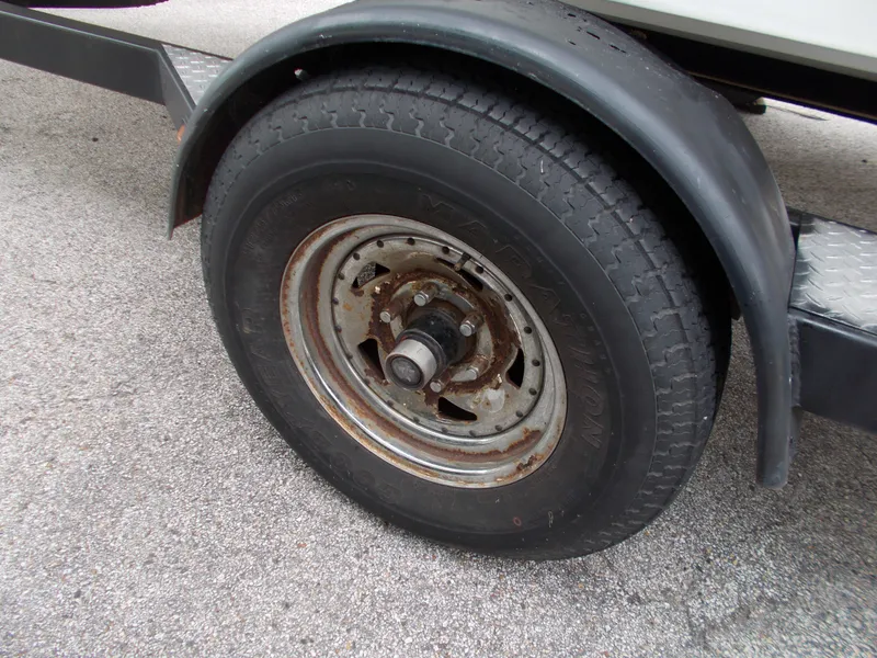 Slide: The Image of Close-up of a 2008 Glastron GT 205 trailer wheel on asphalt. - 2