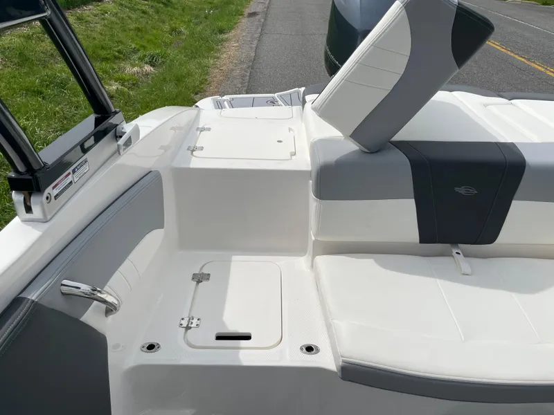 Slide: The Image of 2024 Chaparral 21 SSi OB boat interior, featuring white and gray seating and storage compartments. - 33