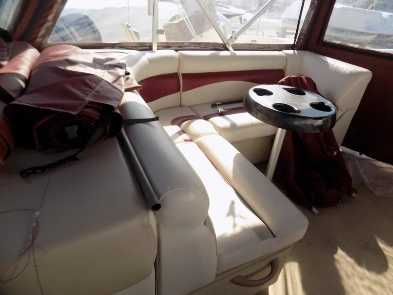 Slide: The Image of Interior of a 2013 Sweetwater 2086 boat with cushioned seating and cup holder table. - 6