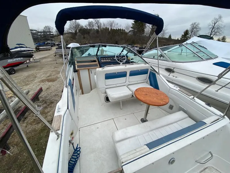 Slide: The Image of 1989 Sea Ray Sundancer boat interior with seating and wooden table. - 10