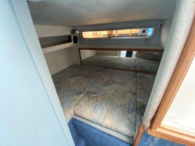 Slide: The Image of 1989 Sea Ray Sundancer cabin interior with bed and window. - 14