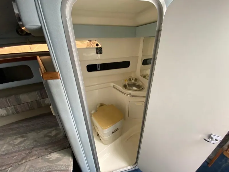 Slide: The Image of 1989 Sea Ray Sundancer interior bathroom with sink and portable toilet. - 15