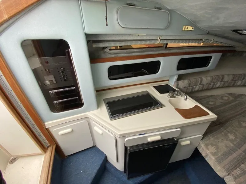 Slide: The Image of Interior of 1989 Sea Ray Sundancer with kitchenette and seating area. - 16
