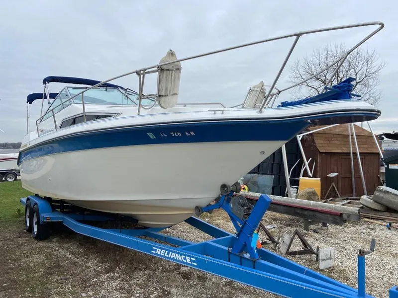 Slide: The Image of 1989 Sea Ray Sundancer boat on a blue trailer, parked outdoors. - 3
