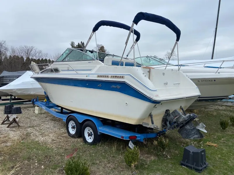 Slide: The Image of 1989 Sea Ray Sundancer boat on a blue trailer, parked outdoors. - 4