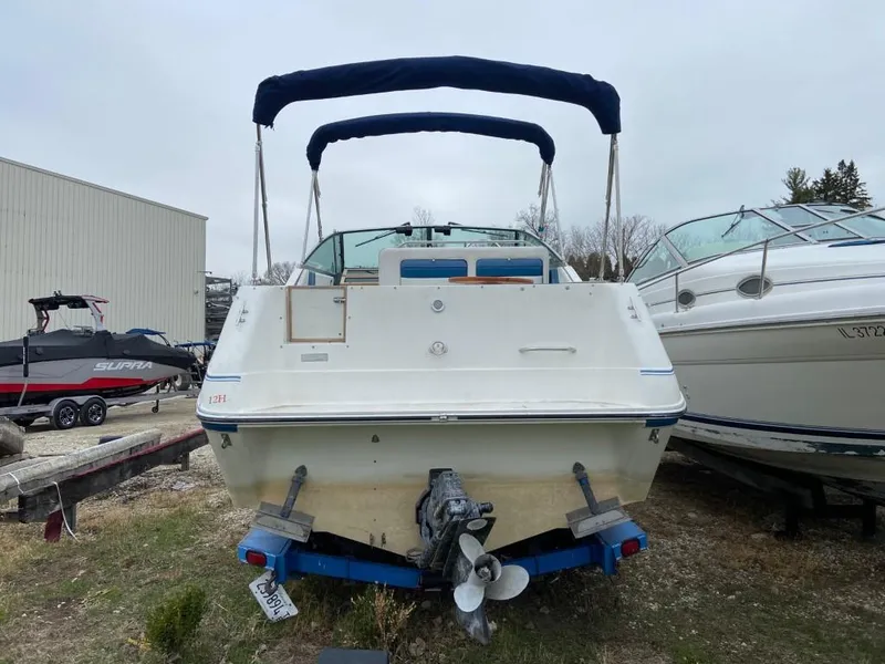 Slide: The Image of 1989 Sea Ray Sundancer boat, rear view, docked between other boats. - 5