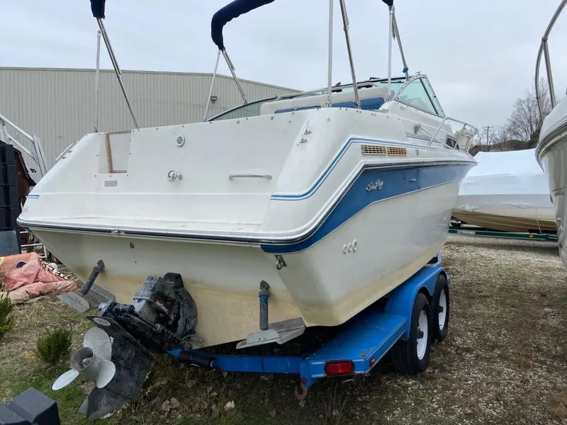 Slide: The Image of 1989 Sea Ray Sundancer boat on a blue trailer in a storage yard. - 6