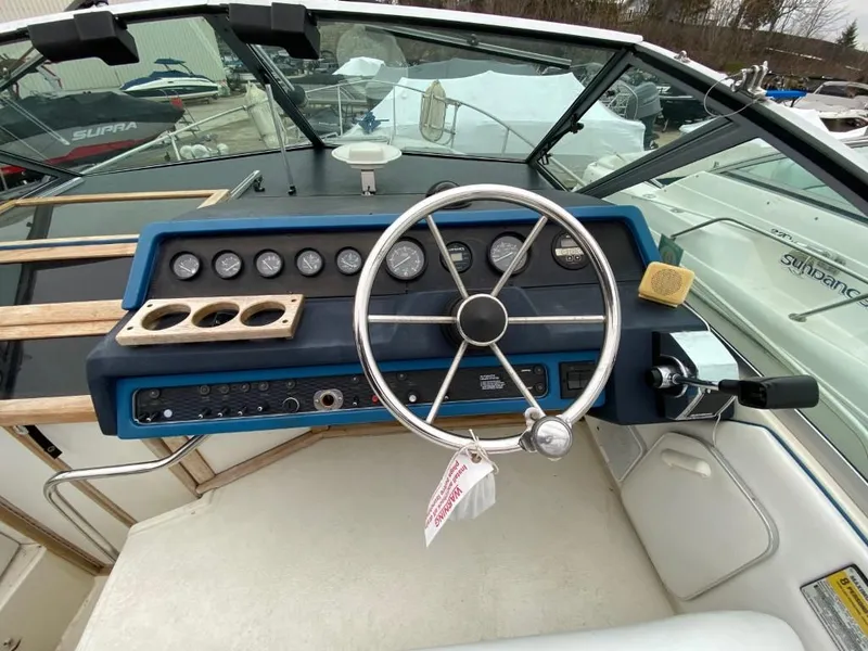 Slide: The Image of 1989 Sea Ray Sundancer boat dashboard with steering wheel and control panel. - 8