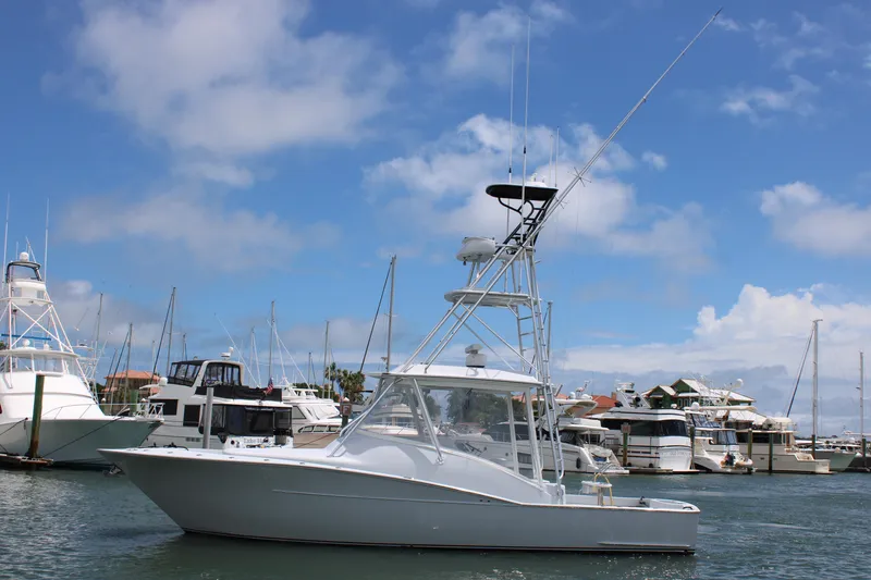 The Image of 2010 Legend 37 Walkaround boat docked in a marina under a blue sky. - 1