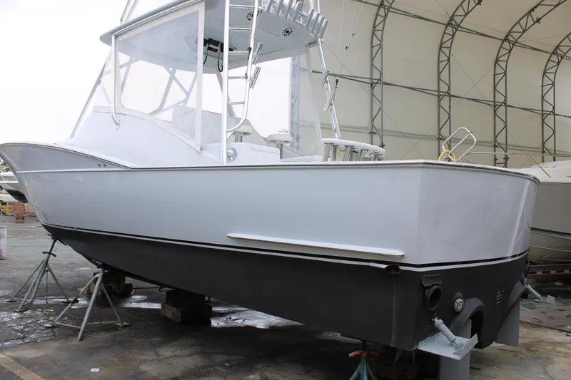 Slide: The Image of 2010 Legend 37 Walkaround boat in storage, white hull, covered facility. - 21