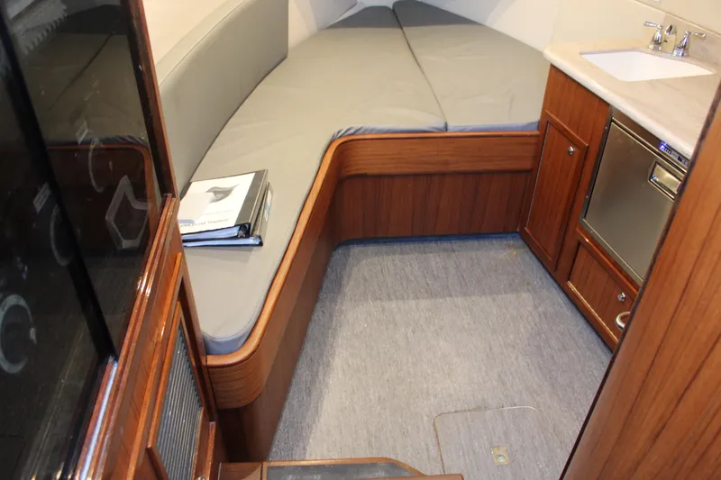 Slide: The Image of 2010 Legend 37 Walkaround cabin interior with bed, sink, and storage. - 5