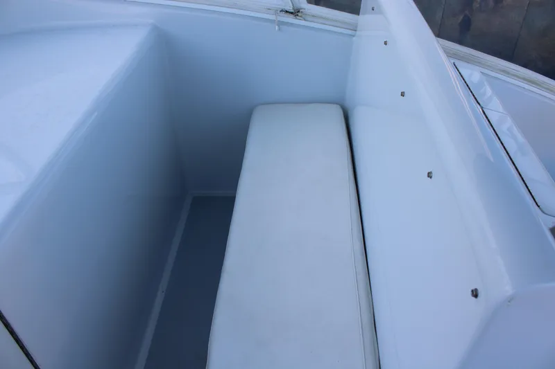 Slide: The Image of 2010 Legend 37 Walkaround boat seating area with white cushioned bench. - 7