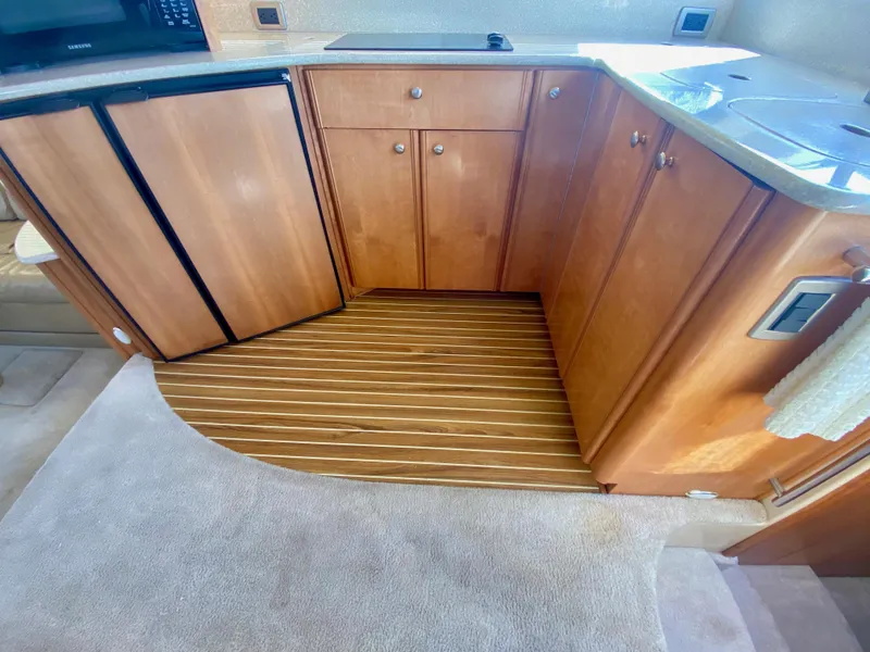 Slide: The Image of The 2004 Meridian 411 Sedan's kitchen features wooden cabinets and a carpeted floor. - 19