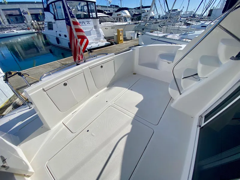 Slide: The Image of The image shows the spacious aft deck of a 2004 Meridian 411 Sedan, docked in a marina. - 26