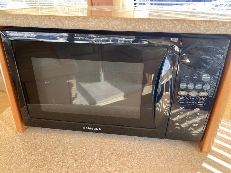 Slide: The Image of A Samsung microwave is built into a kitchenette, surrounded by wood paneling. - 15