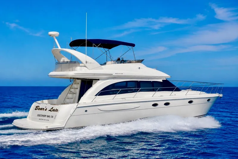 Slide: The Image of 2004 Meridian 411 Sedan yacht cruising on open blue sea under clear sky. - 42