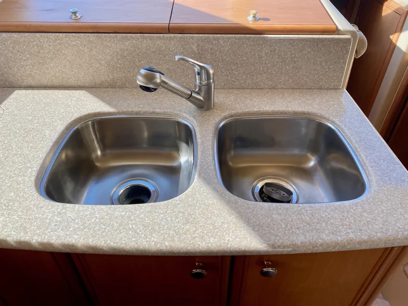 Slide: The Image of Double stainless steel sink with modern faucet in a countertop, surrounded by wood paneling. - 18