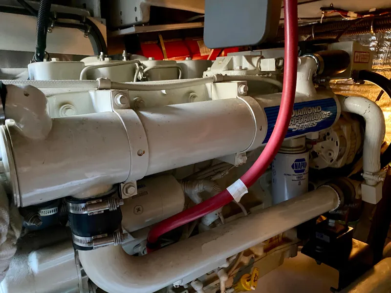 Slide: The Image of An engine room with a large white engine and red hoses. - 34
