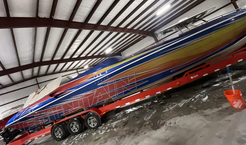 The Image of 1999 Fountain 47 Lightning speedboat on a red trailer in a warehouse. - 0