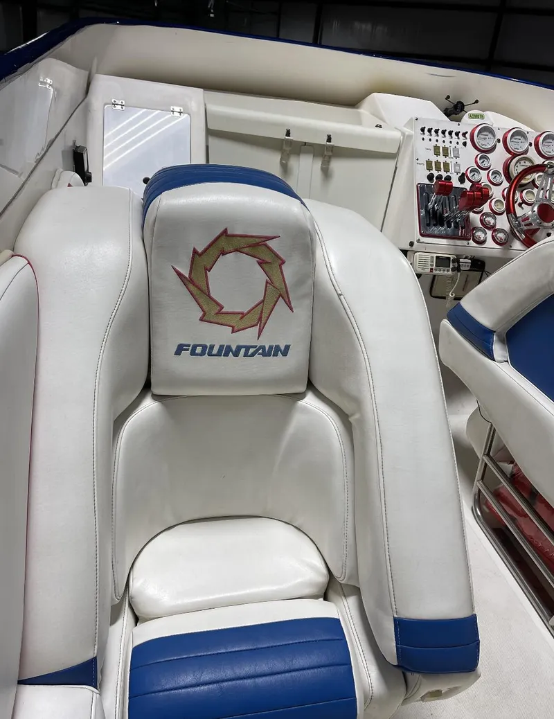 Slide: The Image of 1999 Fountain 47 Lightning boat interior with white and blue seating and control panel. - 10