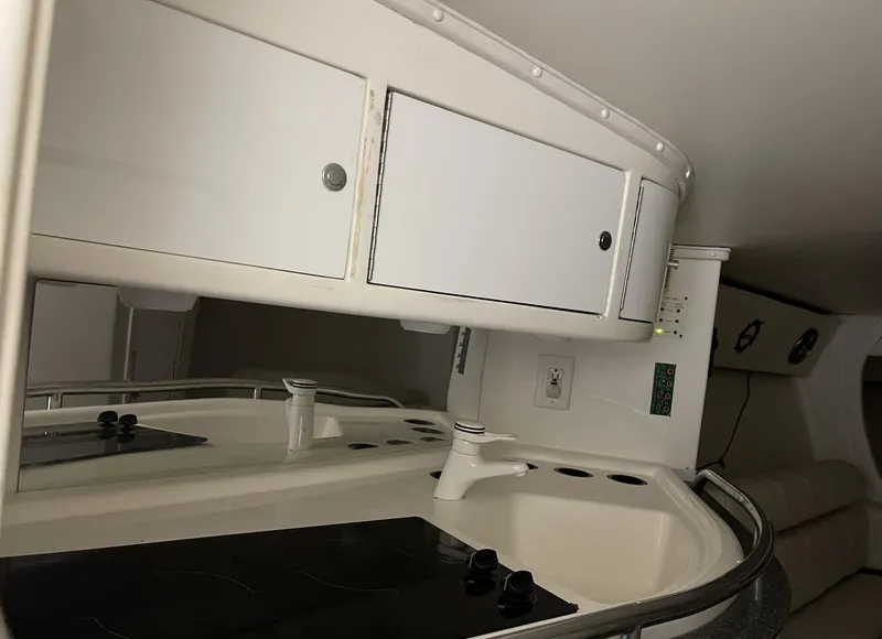 Slide: The Image of 1999 Fountain 47 Lightning boat interior kitchen with white cabinets and sink. - 14