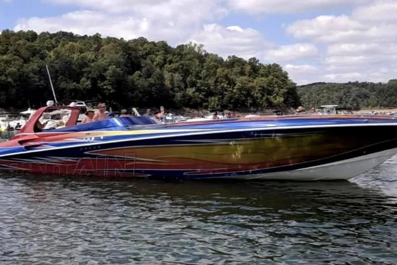 Slide: The Image of 1999 Fountain 47 Lightning speedboat on a lake with forested background. - 2