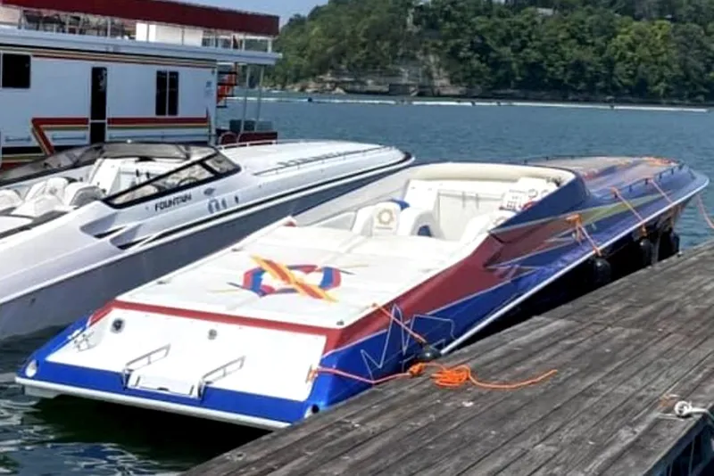 Slide: The Image of 1999 Fountain 47 Lightning speedboat docked beside another boat on a sunny day. - 8