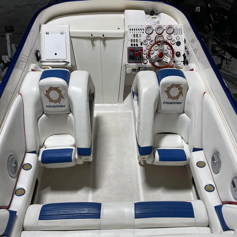 Slide: The Image of 1999 Fountain 47 Lightning boat interior with white and blue seating, detailed dashboard. - 9