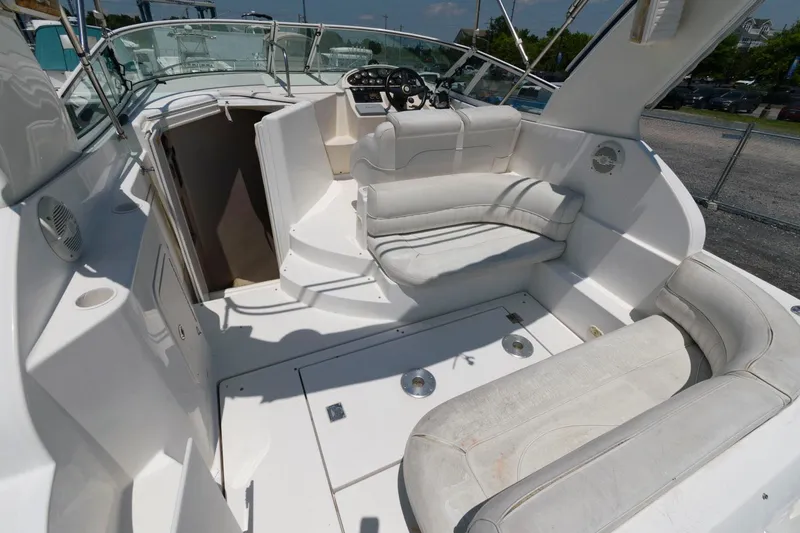 Slide: The Image of 2000 Cruisers Yachts 2870 Express boat interior with white seating and helm station. - 2