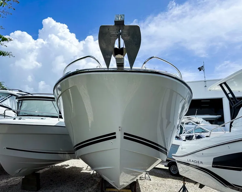 Slide: The Image of 2024 Jeanneau LEADER 9.0CC boat, front view, displayed outdoors under a blue sky. - 2