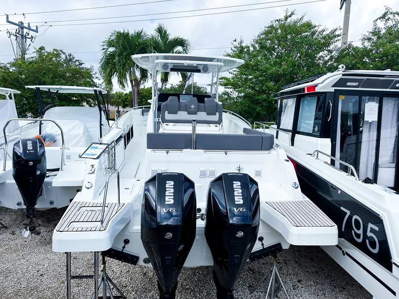 Slide: The Image of 2024 Jeanneau LEADER 9.0CC boat with dual outboard engines, docked outdoors. - 4