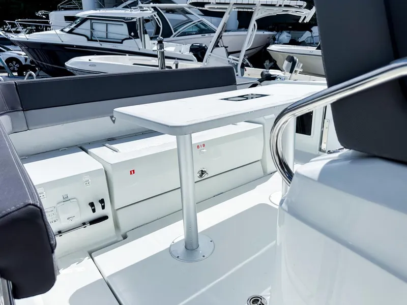Slide: The Image of 2024 Jeanneau LEADER 9.0CC boat interior with seating and table, docked among other boats. - 8