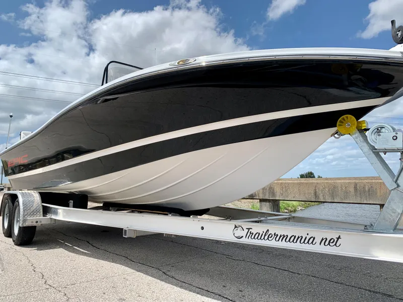 Slide: The Image of 2015 Epic 22SC Bay Boat on trailer, black and white hull, clear sky background. - 12