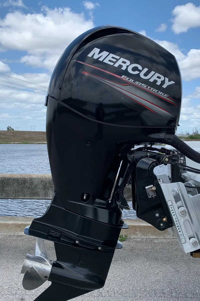 Slide: The Image of 2015 Epic 22SC Bay Boat with Mercury outboard motor by the water. - 23