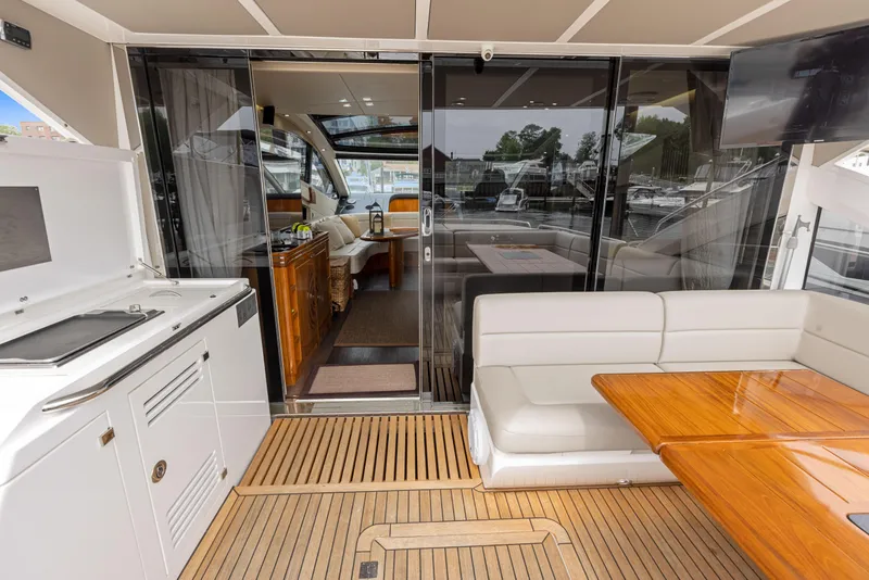 Slide: The Image of Sunseeker Predator 68 2015 yacht interior with seating, table, and kitchenette. - 10